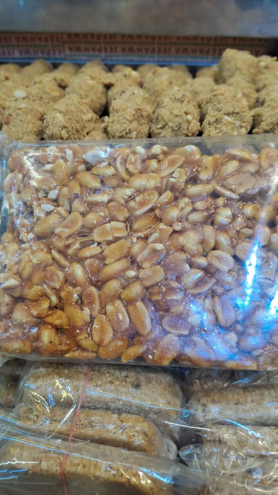 A large wrapped peanut chikki slab on the sweets counter.