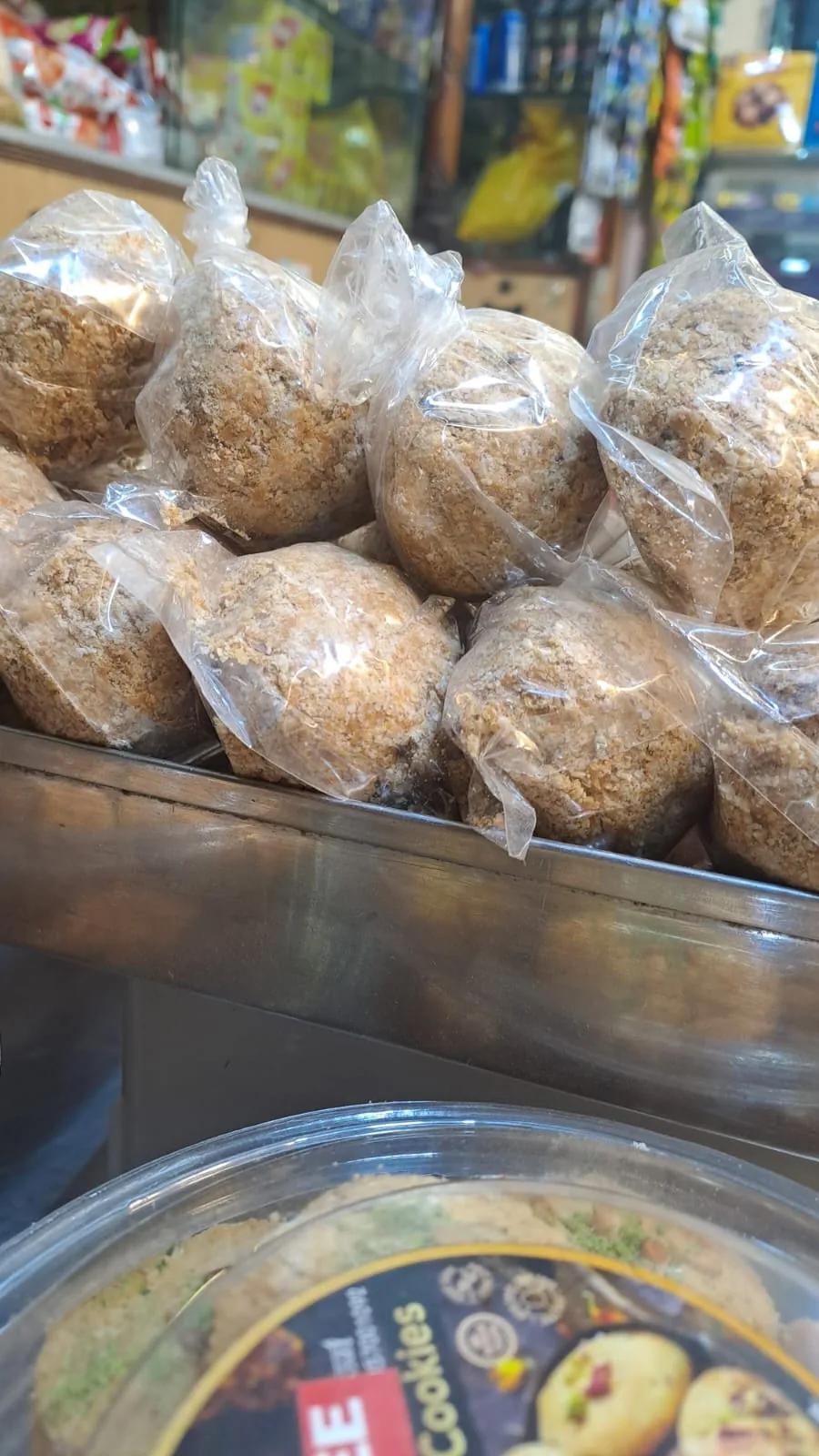 Individually wrapped gazak rolls stacked on the counter.