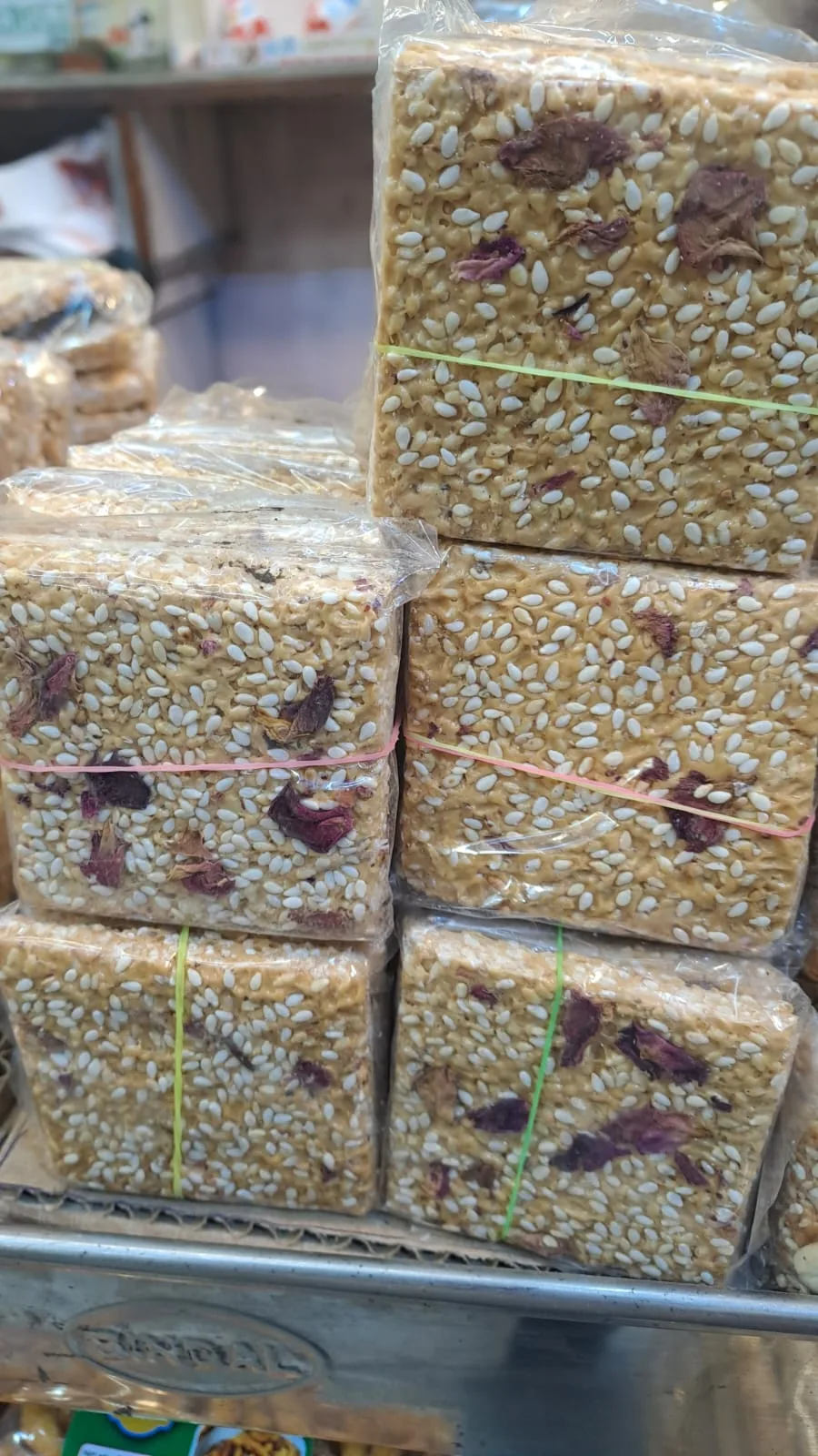 Wrapped blocks of sesame chikki studded with nuts.