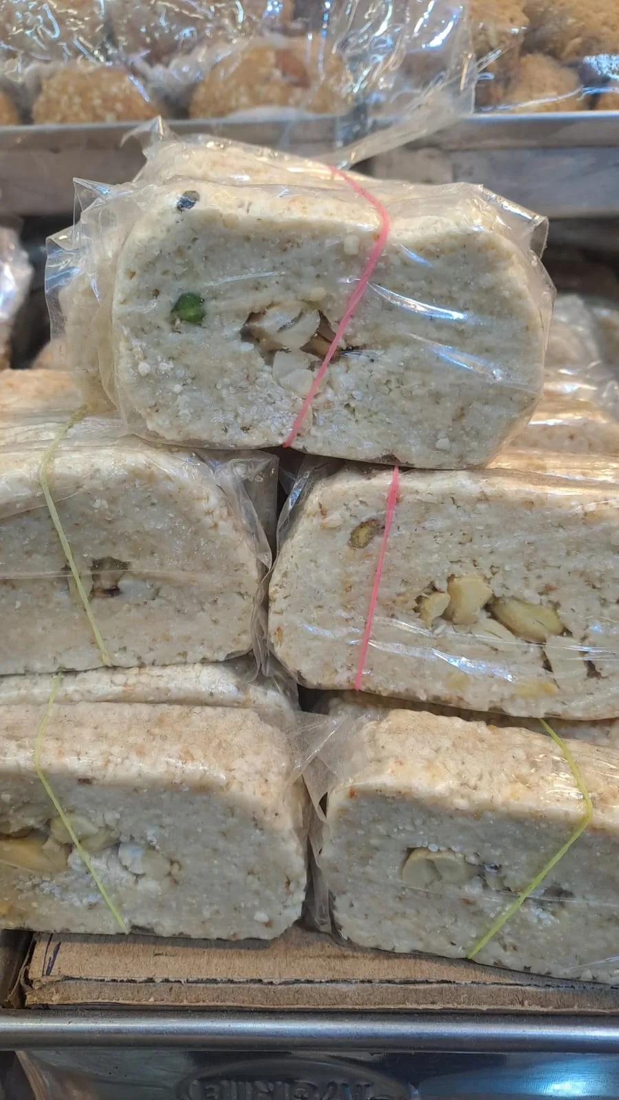 Pale gazak blocks with visible nuts stacked in clear wrapping.