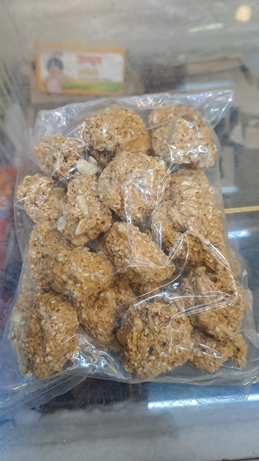 A clear packet of small sesame gazak pieces with nuts.