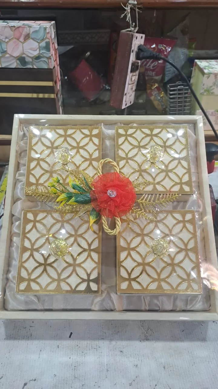 A gold-patterned gift box wrapped with a flower decoration.