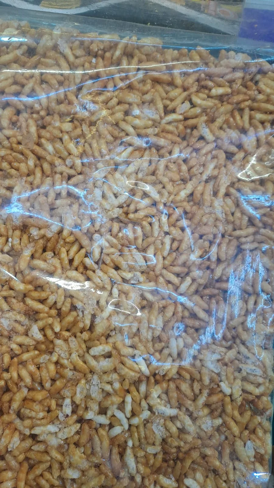 A close-up of a wrapped puffed-rice chikki slab.