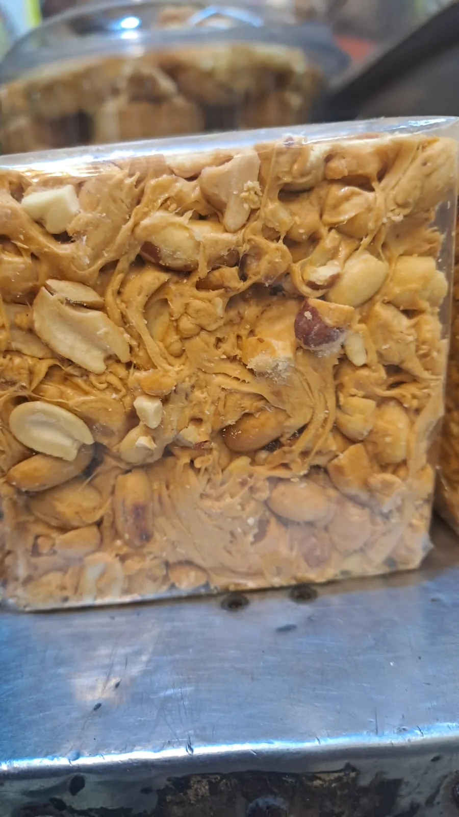 A wrapped block of chikki filled with peanut halves.