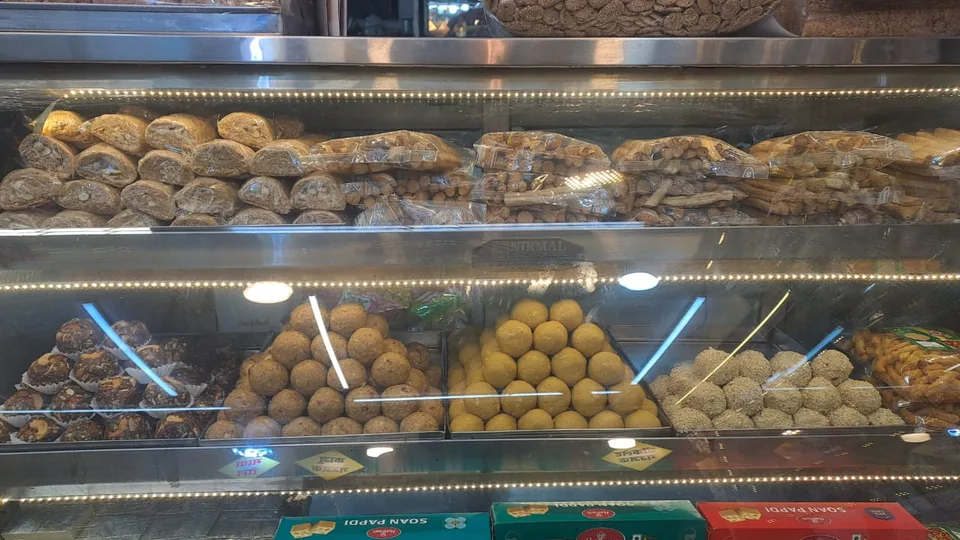 A glass display case with gazak above trays of assorted sweets.