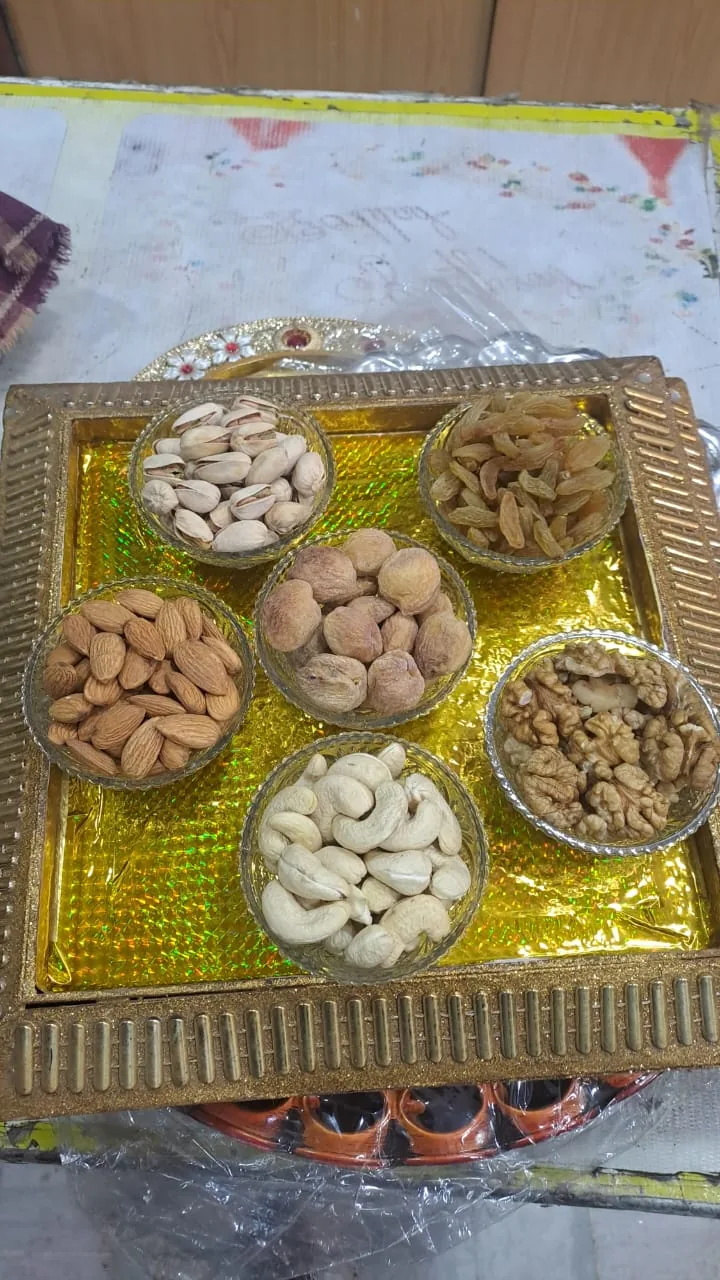 A gold gift tray with separate bowls of assorted dry fruits.