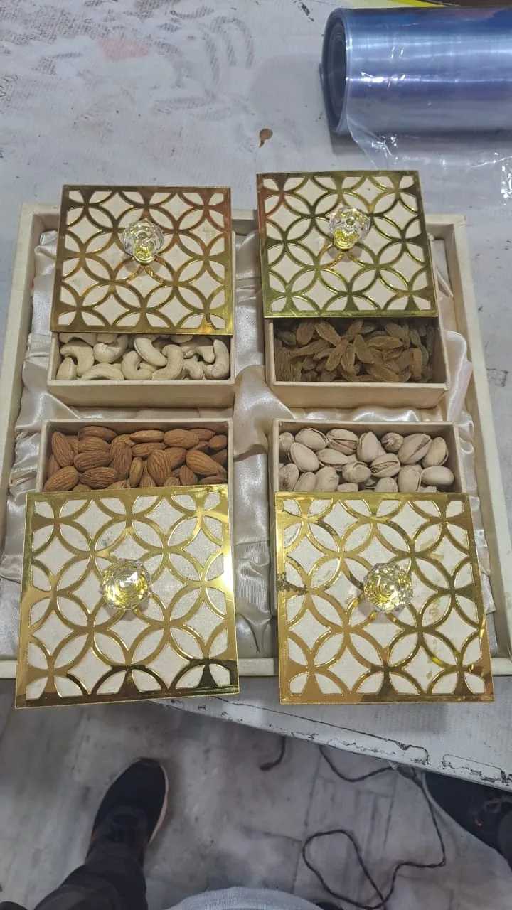 Open gold-patterned gift boxes containing assorted dry fruits.