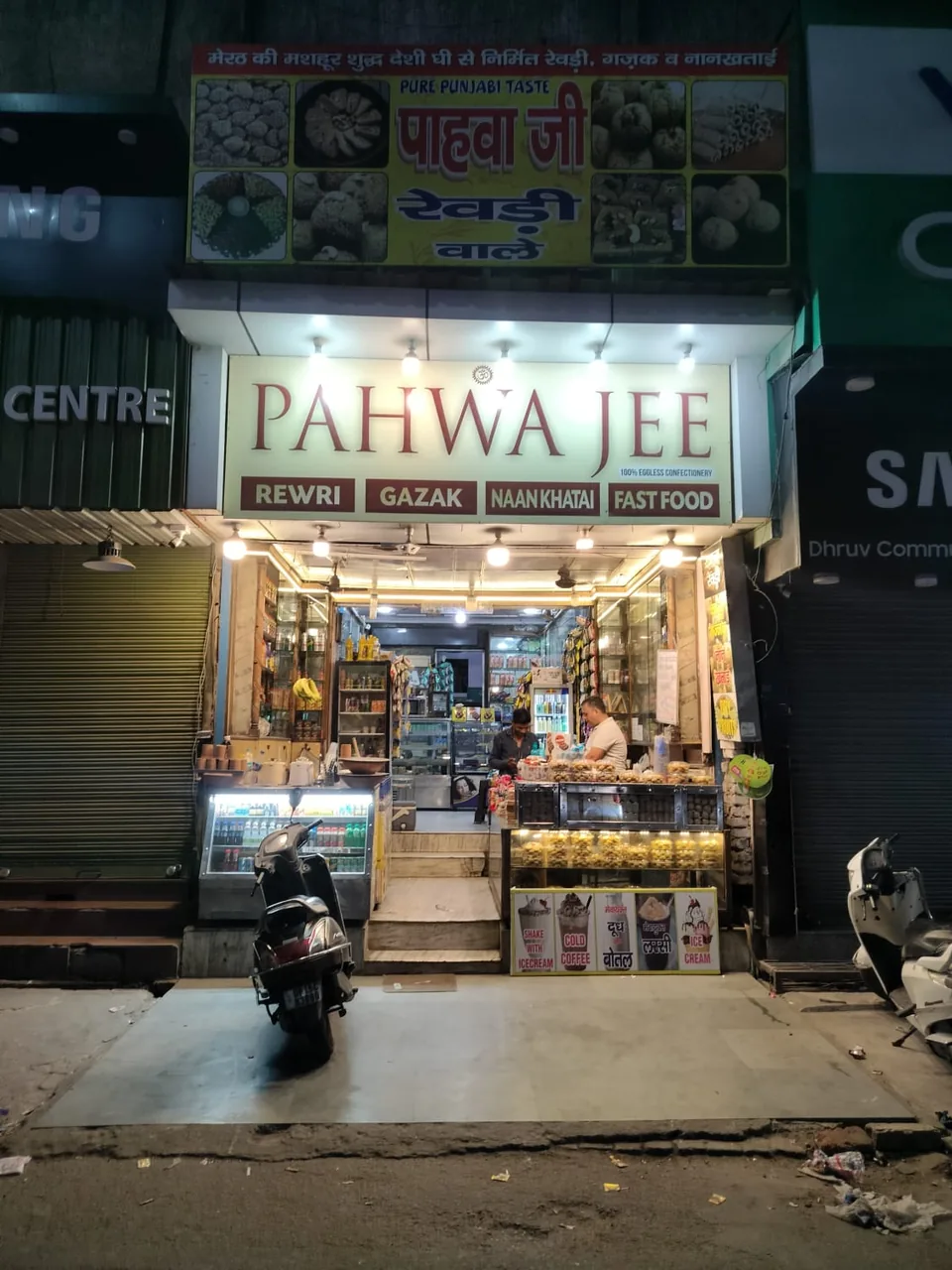 The illuminated PAHWA JEE shop entrance photographed at night.