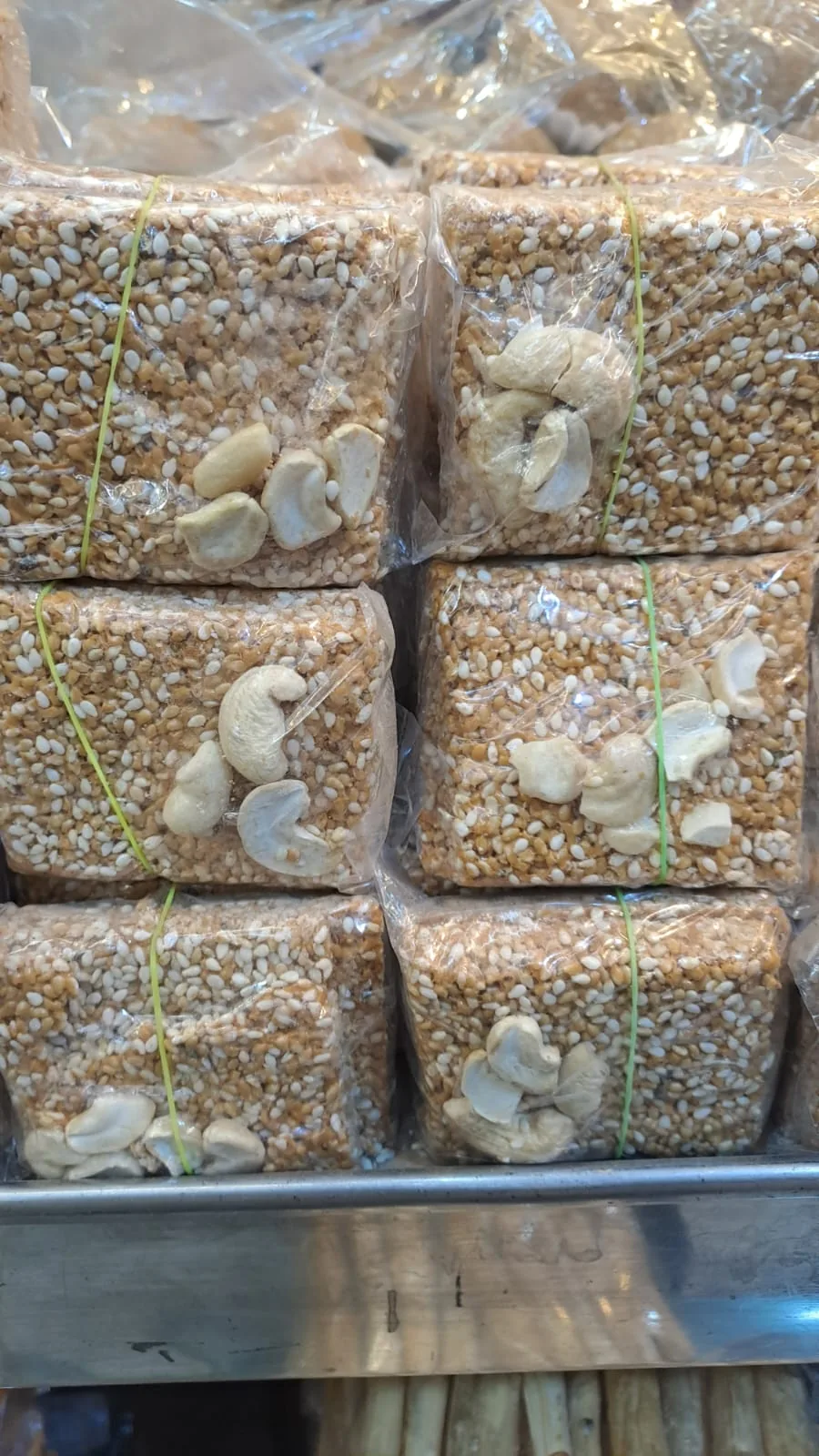 Stacks of sesame chikki blocks decorated with cashews.